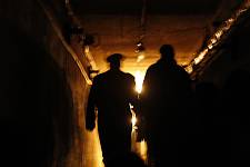 Not far away from Vilnius, in the woods, there is a secret two-level underground maze spread over 3,000 square meters in a 2 ha closed territory. It was built in 1980 as a backup TV station in case of a nuclear war with the US. But there was no war, and the bunkers were seized by the USSR army in 1991 during Lithuania's fight for independence. Lithuania regained independence and became a member of EU. 5 meters below the ground, and you find yourself in the USSR. Here you can avail of the opportunity to be transferred to the past and become a citizen of a totalitarian state. Upon arrival you will be met by guards with dogs. Having waved goodbye to your belongings, currency, cameras and mobile phones, you will put on a Soviet threadbare coat and dive into the life of a USSR citizen, full of tension and social peculiarities. You'll be taken to the maze, watch TV shows and shops of 1984, be interrogated in a KGB office, learn the anthem of the USSR and get used to wearing a gas mask. You'll dance to the music of those times and will make a Soviet dinner yourself. Leaving the bunker you will receive a special certificate and a unique present from the Soviet times.