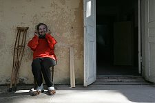 The female patient who is at liberty to walk around the grounds is sitting in the chair near the entrance to the hospital. Mental hospital not far from Sukhumi, Abkhasia, Friday, March 17, 2006. About a hundred patients and several members of the staff are placed in a small two-storeyed building. It's the only hospital of the kind in Abkhasia which was badly damaged in the war. The hospital could never do without its head physician Konstantin Anua.