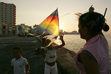 Children playing on the shore. The coastline is the walking zone for tourists and locals, a place for morning runs, a meeting place of  street musicians, children and freelance artists. Flyinf a kite is a popular children's amusement. Habana, Cuba, Thursday, Feb. 22, 2007.