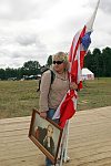 Activist of the pro-Kremlin Nashi (Ours) youth movement from Briansk with the flags of the organisation and Vladimir Putin portrait in the Nashi summer camp on Lake Seliger, some 300 kilometres (~180 miles) northwest of Moscow, Sunday, July 15, 2007. Pro-Kremlin Nashi (Ours) youth movement has assembled about 10 thousand young people from all over Russia to a summer camp where they are going to do sports and attend political and socially oriented lectures and training sessions for two weeks.